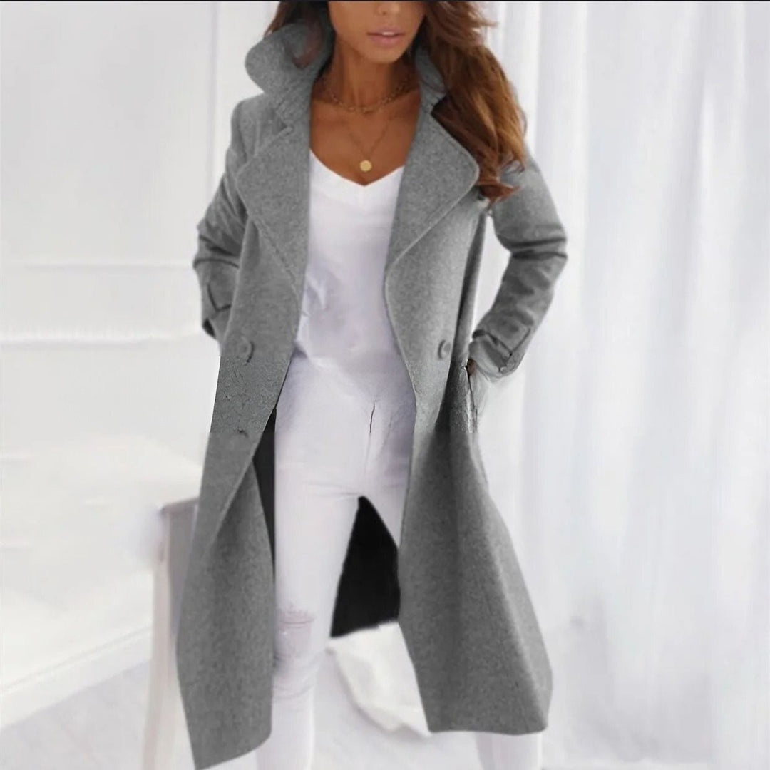 Person wearing a gray coat over a white outfit on a white background
