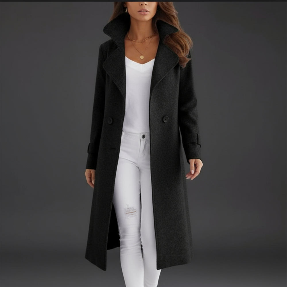 Person wearing a long black coat over a white outfit on a white background