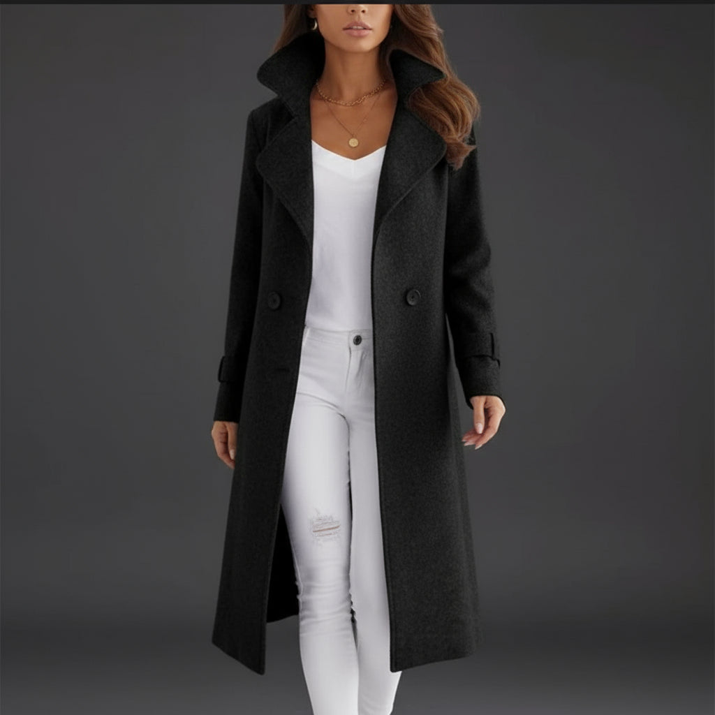 Person wearing a long black coat over a white outfit on a white background