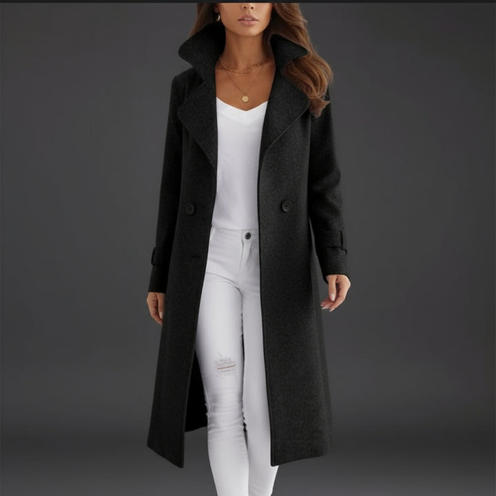 Person wearing a long black coat over a white outfit on a white background