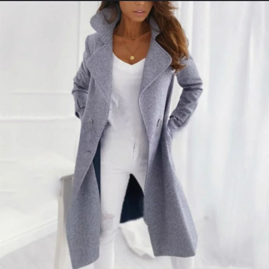Woman wearing a gray coat over a white outfit on a white background