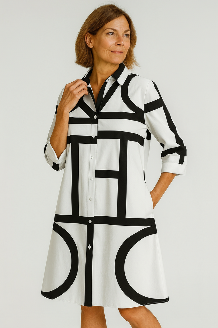 Woman wearing a black and white patterned dress on a plain background