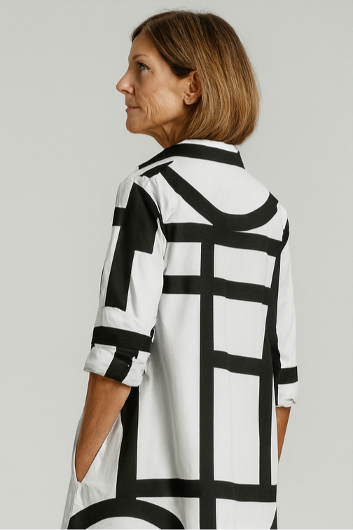 Woman wearing a black and white patterned shirt against a plain background