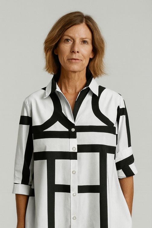 Woman wearing a black and white patterned shirt against a plain background