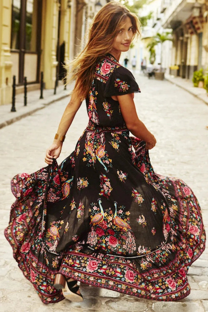 Woman wearing a long, floral dress walking down a street.
