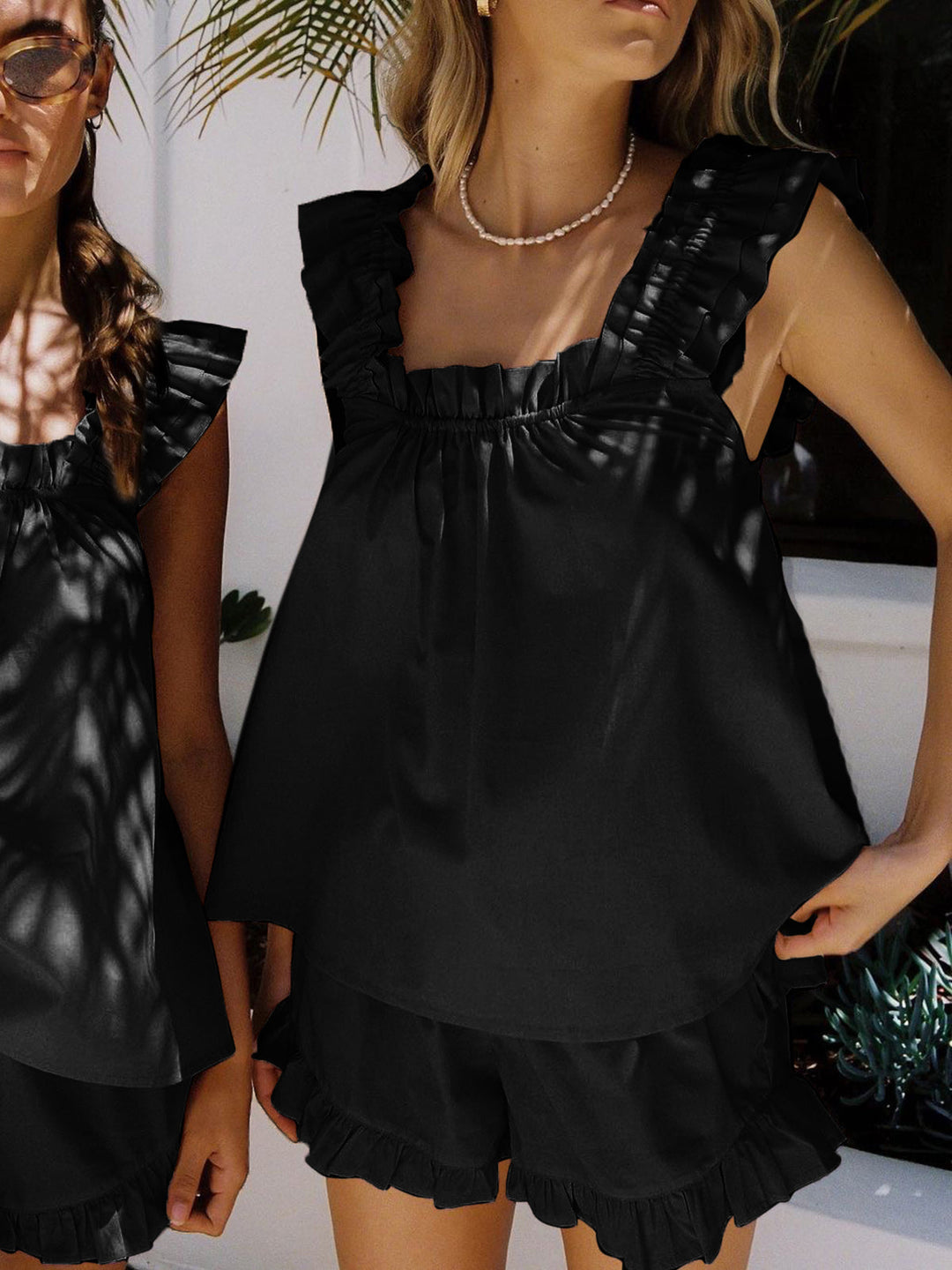 Woman wearing a black dress with ruffled hem outdoors