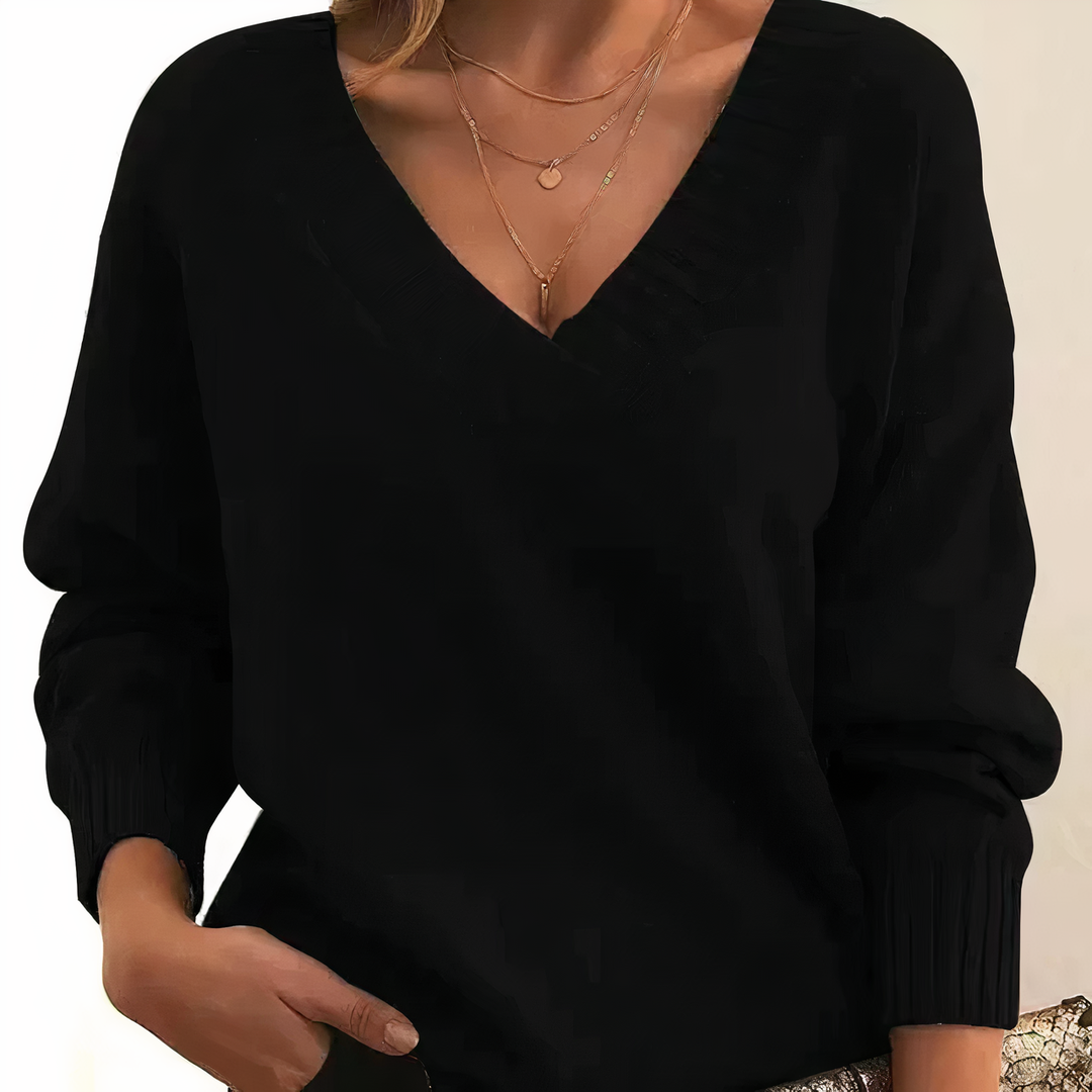 Black sweater worn by a person on a neutral background