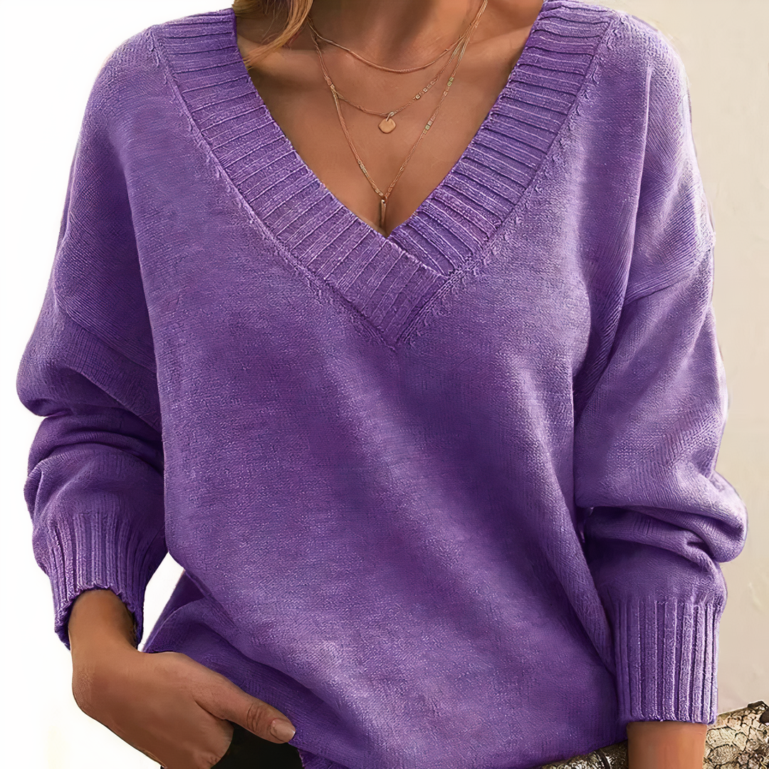 Purple sweater worn by a person on a neutral background