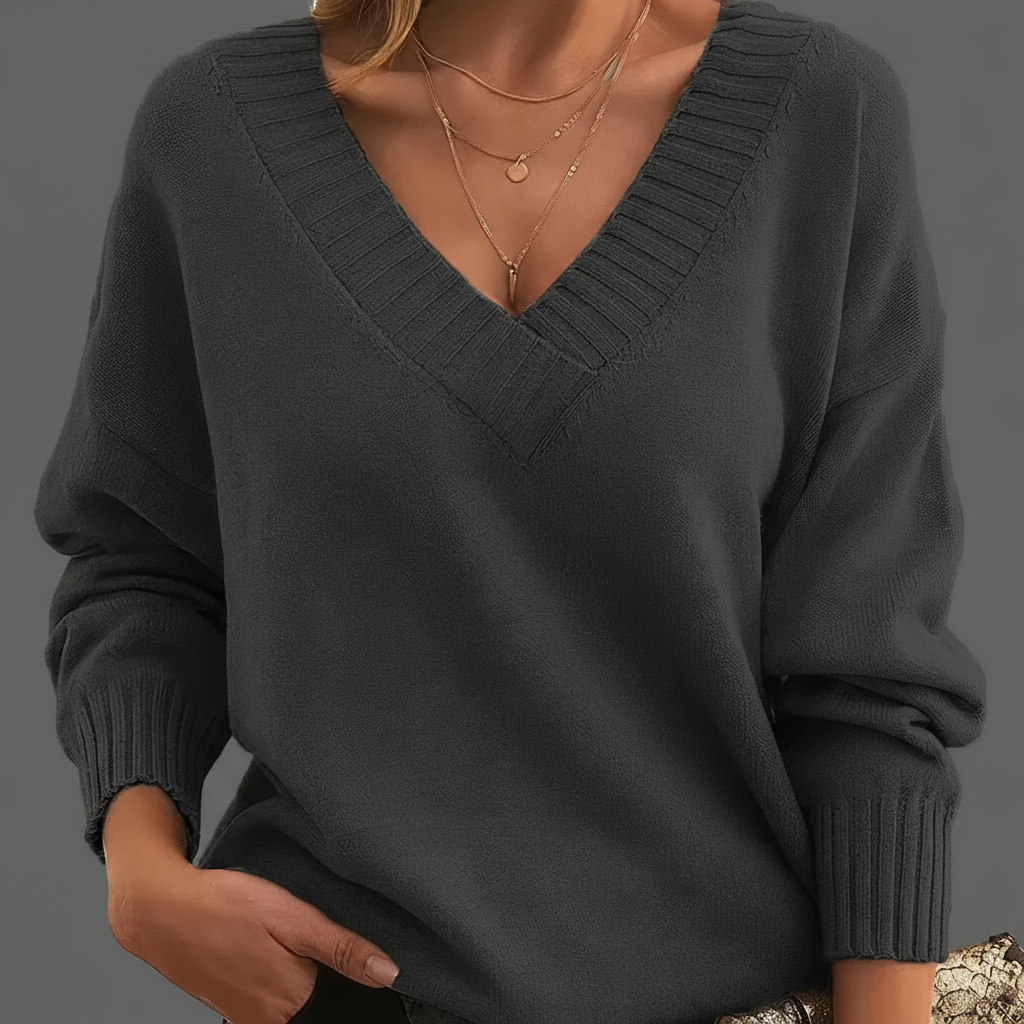 Dark gray sweater worn by a person on a neutral background