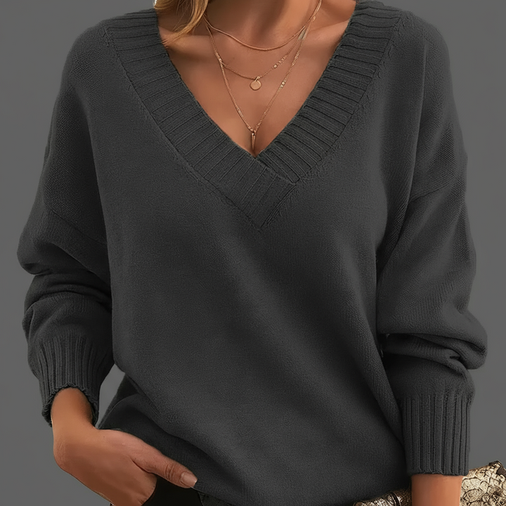 Dark gray sweater worn by a person on a neutral background