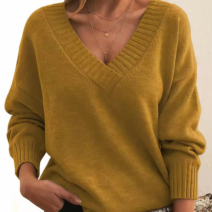 Mustard yellow sweater worn by a person on a plain background