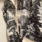 Black and white patterned fabric with classical design on a beige background