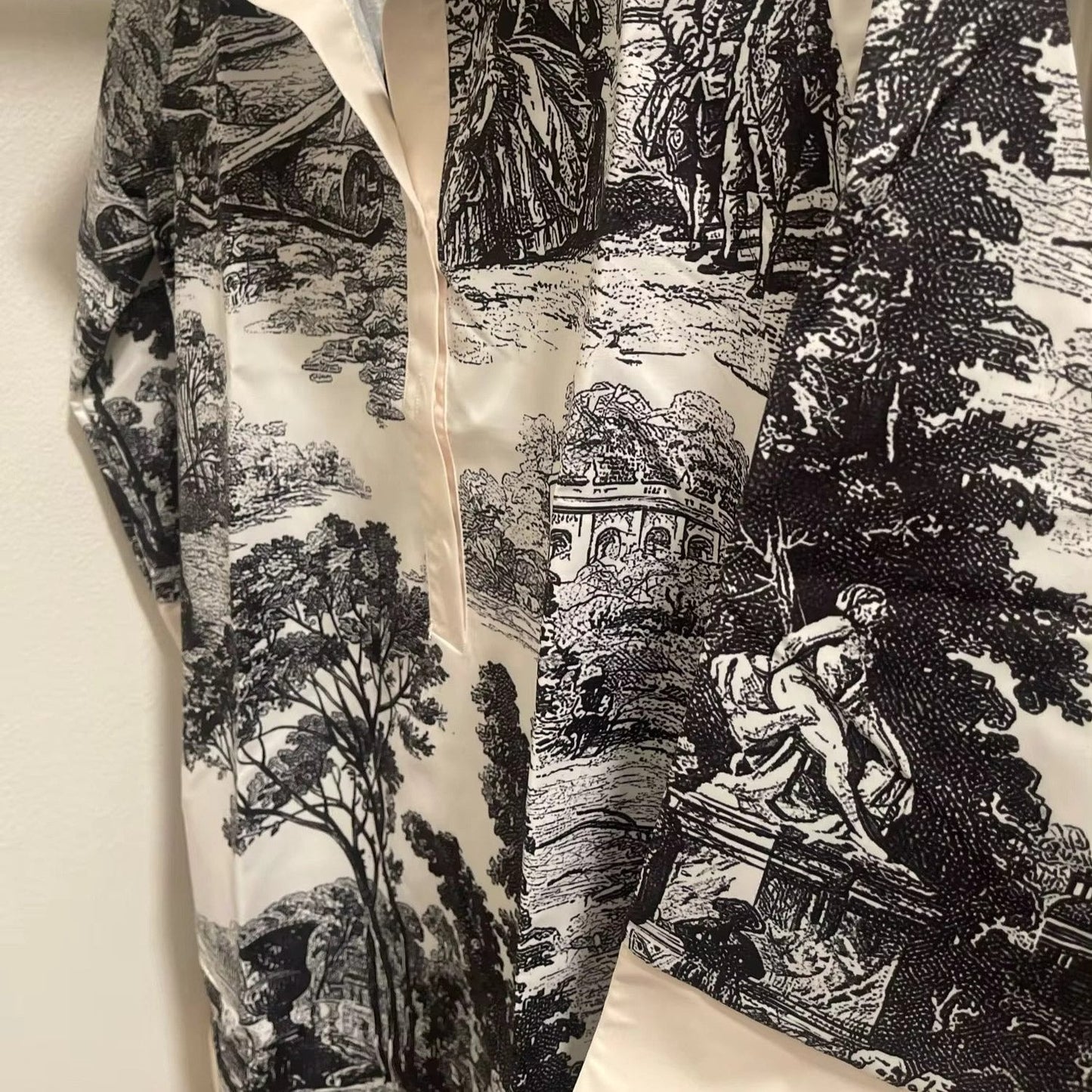 Black and white patterned fabric with classical design on a beige background