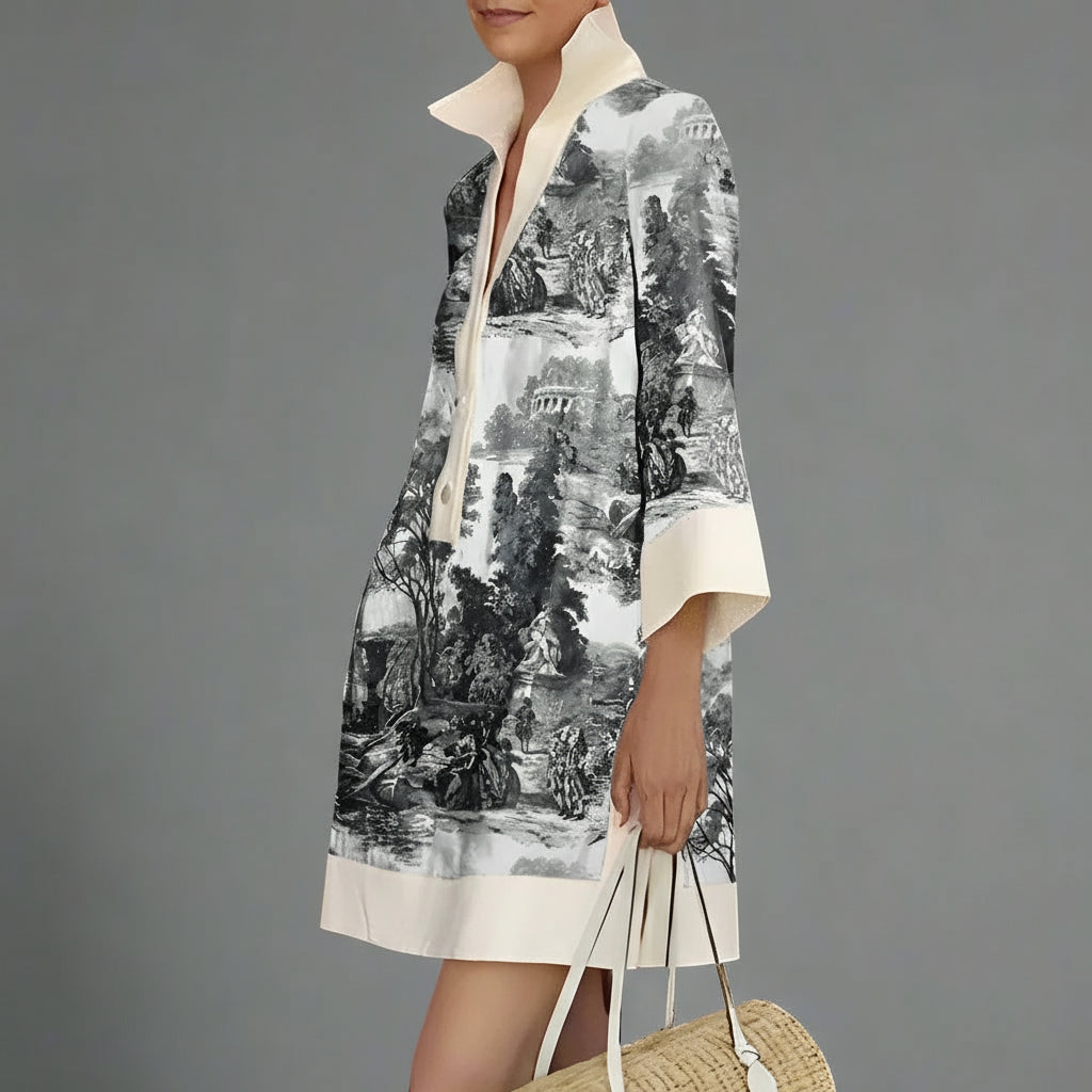 Person wearing a black and white patterned dress with a plain background